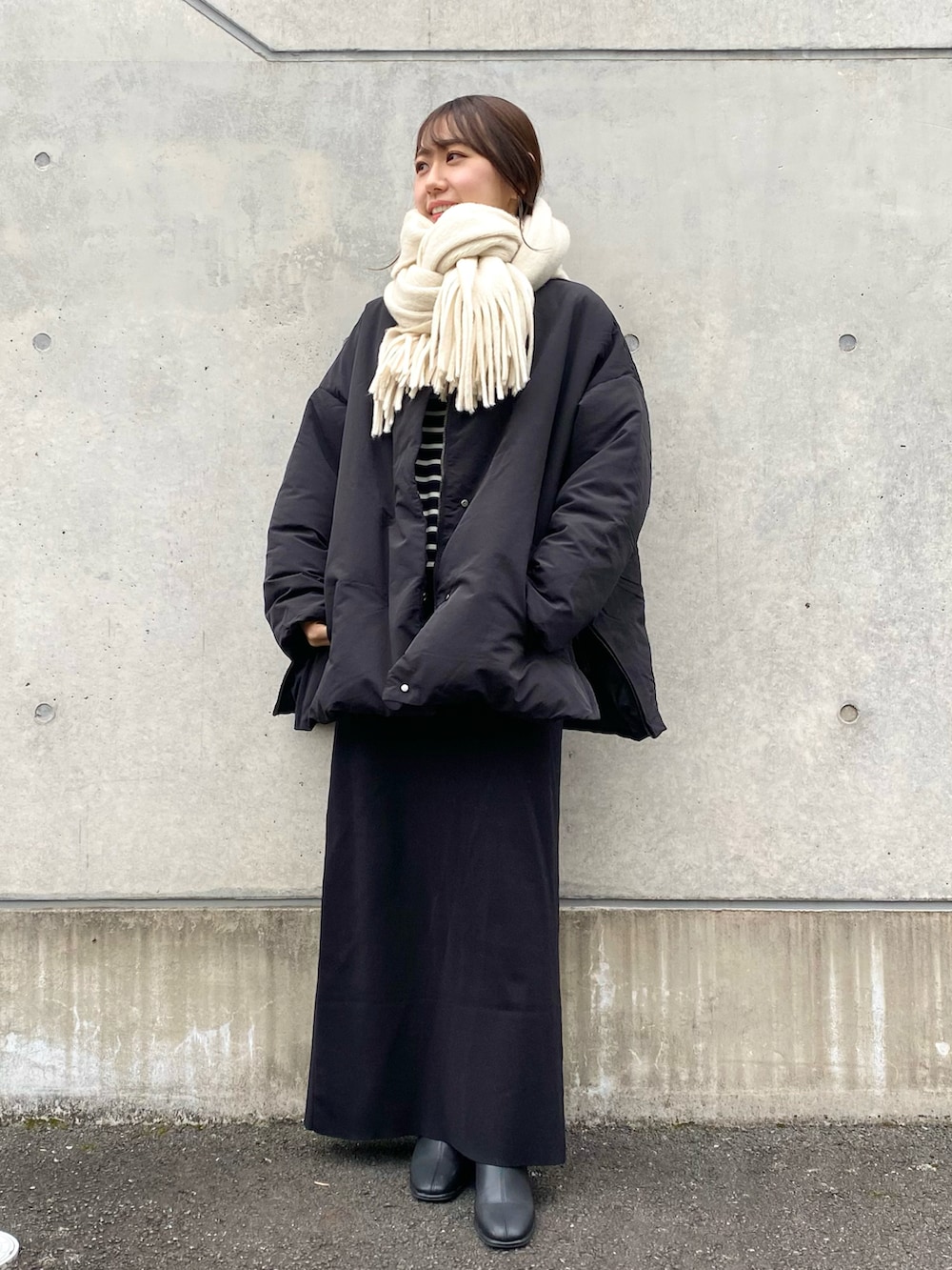 ブラック系のダウンジャケット/コート、ブラック系のスカート、ブラック系のその他シューズを着用したレディースの冬コーディネートの3枚目の写真