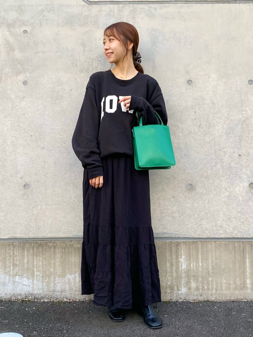 ブラック系のその他シューズ、ブラック系のスカート、グリーン系のトートバッグを着用したレディースの冬コーディネートの3枚目の写真