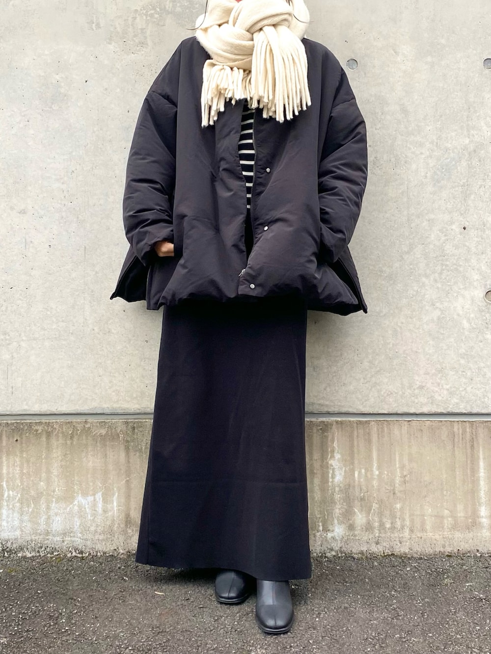 ブラック系のダウンジャケット/コート、ブラック系のスカート、ブラック系のその他シューズを着用したレディースの冬コーディネートの2枚目の写真