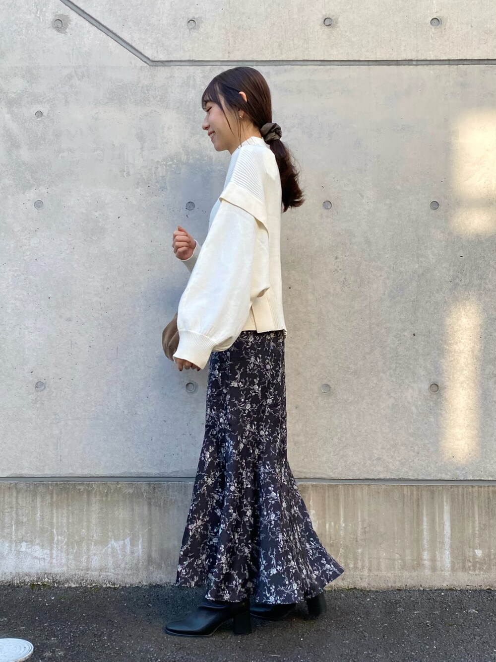 ホワイト系のニット/セーター、ブラック系のスカート、ブラック系のブーツを着用したレディースの冬コーディネートの3枚目の写真