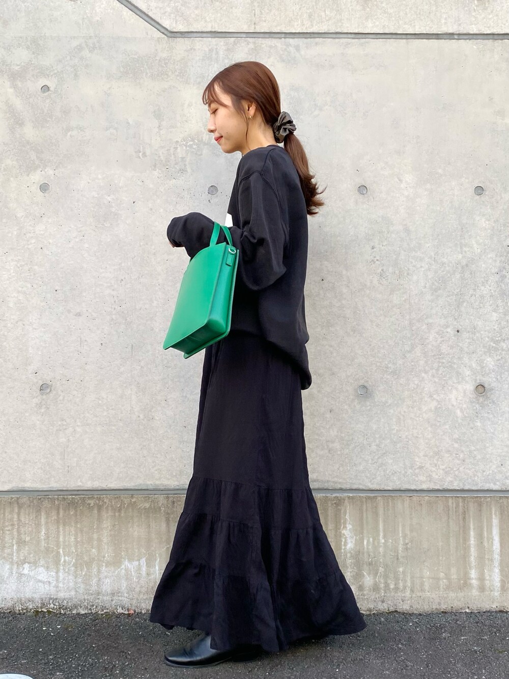 ブラック系のその他シューズ、ブラック系のスカート、グリーン系のトートバッグを着用したレディースの冬コーディネートの2枚目の写真