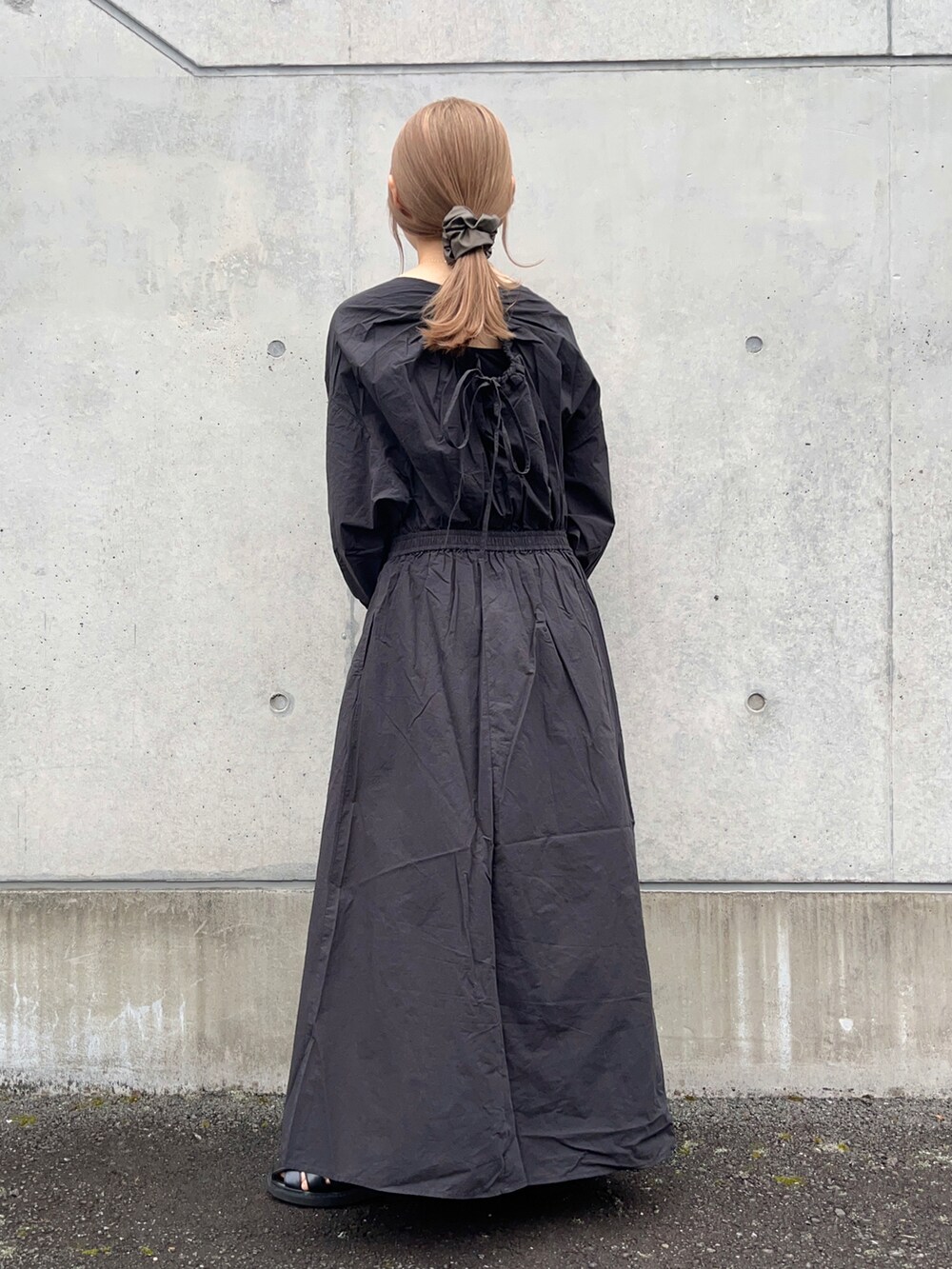 ブラック系のワンピース、グリーン系のトートバッグ、ブラック系のサンダルを着用したレディースの春コーディネートの4枚目の写真