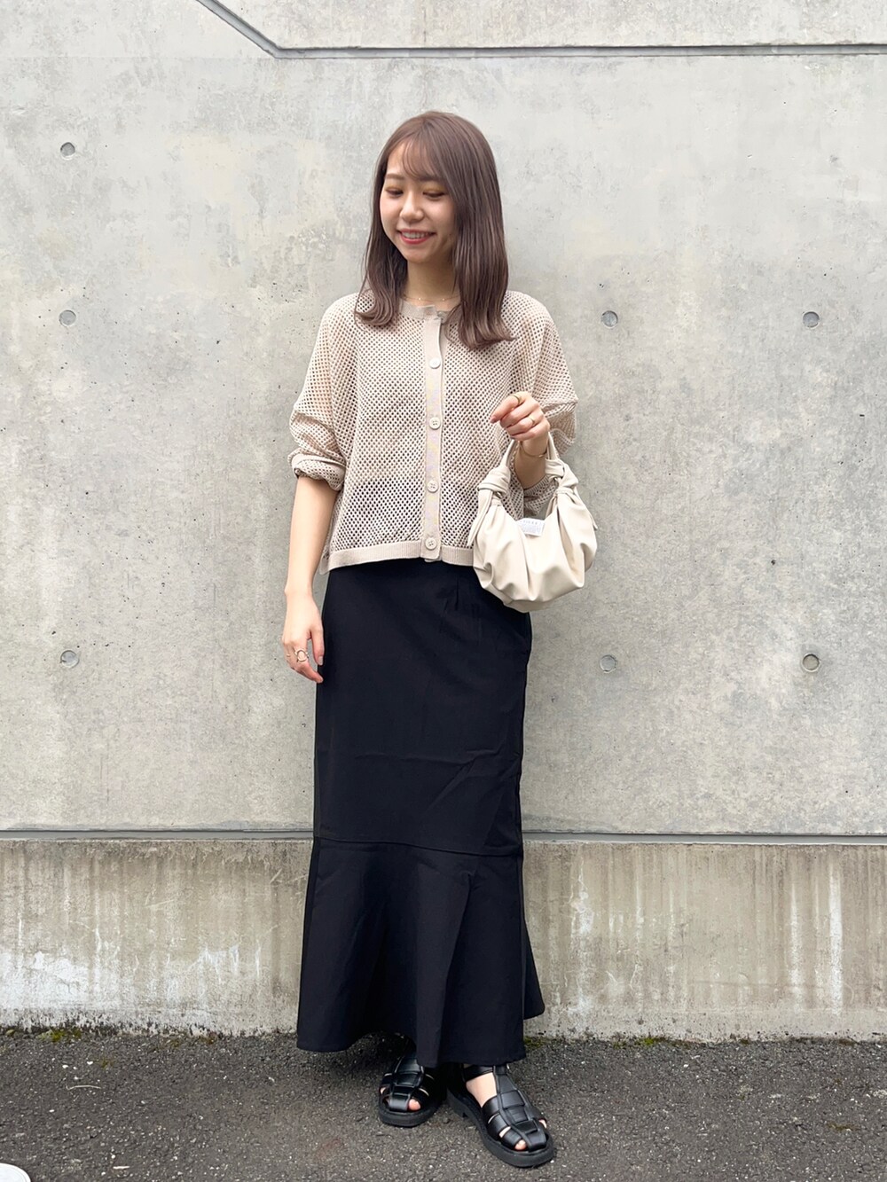 ベージュ系のカーディガン/ボレロ、ブラック系のスカート、ブラック系のサンダルを着用したレディースの春コーディネートの2枚目の写真