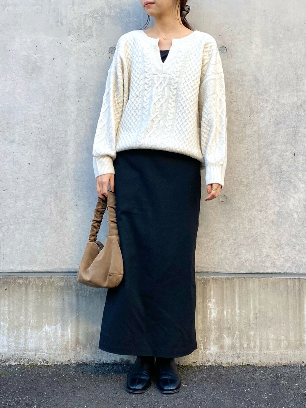 ホワイト系のニット/セーター、ブラック系のスカート、ブラック系のキャミソールを着用したレディースの冬コーディネートの2枚目の写真