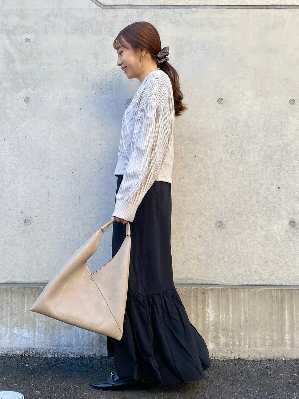 ベージュ系のワンピース、ベージュ系のトートバッグ、ブラック系のローファーを着用したレディースの冬コーディネートの3枚目の写真