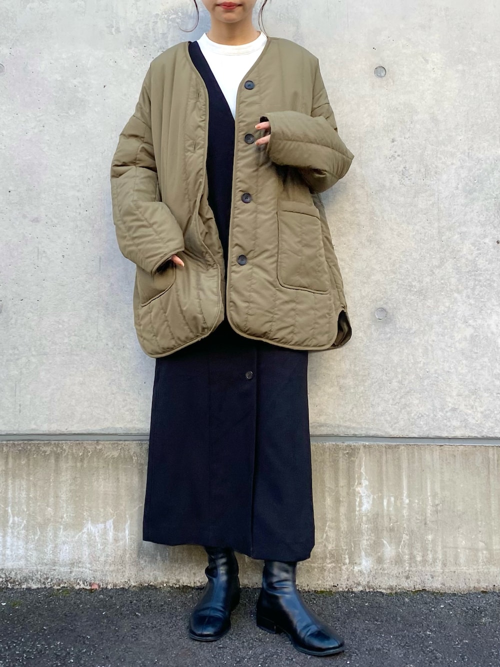 グリーン系のその他アウター、ブラック系のジャンパースカート、ホワイト系のTシャツ/カットソーを着用したレディースの冬コーディネートの2枚目の写真