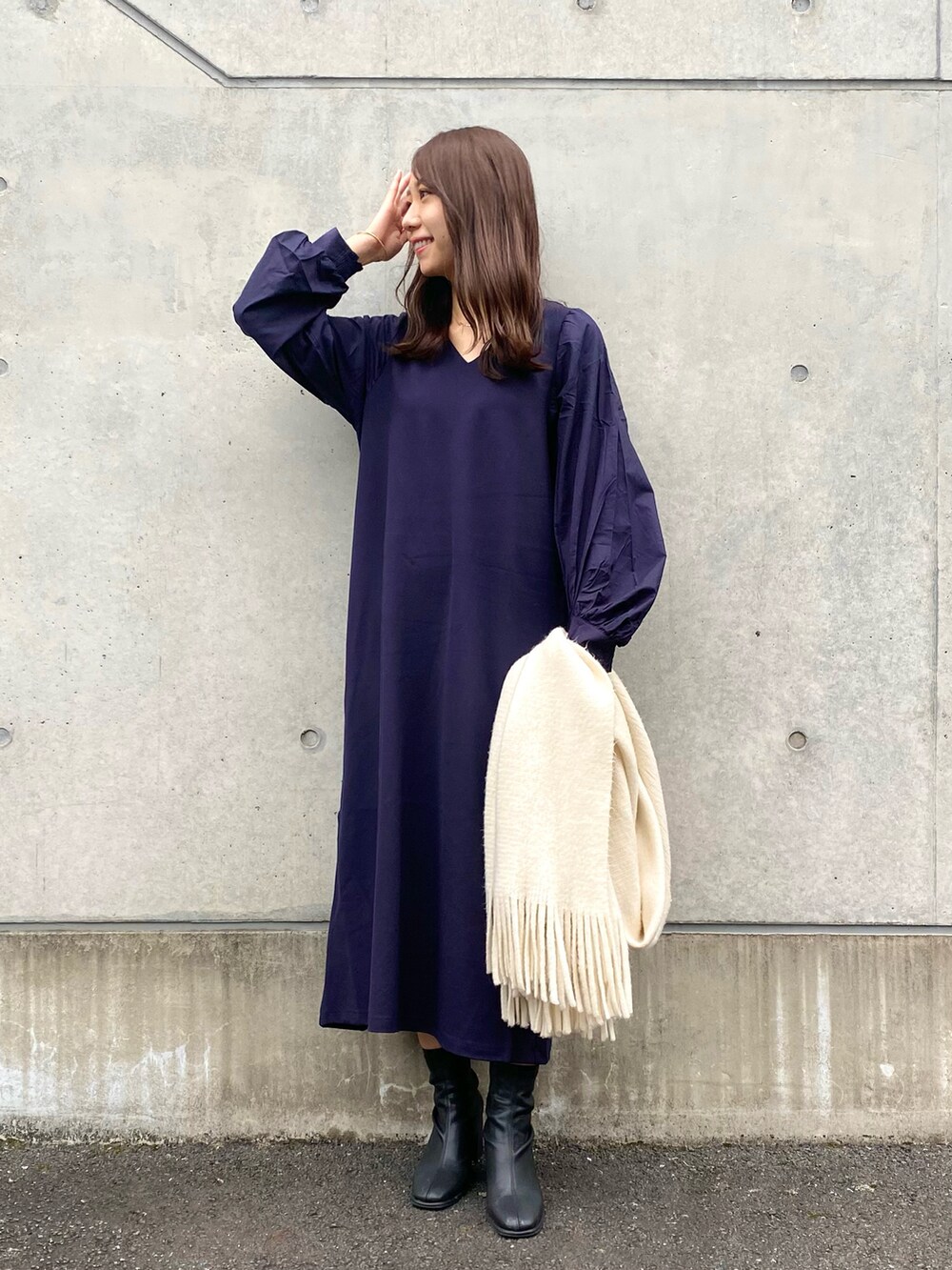 ブルー系のワンピース、ブラック系のブーツ、ホワイト系のマフラーを着用したレディースの秋コーディネートの4枚目の写真