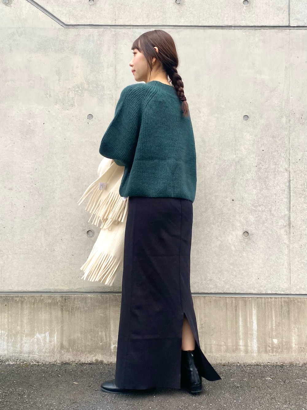 グリーン系のニット/セーター、ブラック系のその他シューズ、ホワイト系のマフラーを着用したレディースの冬コーディネートの3枚目の写真