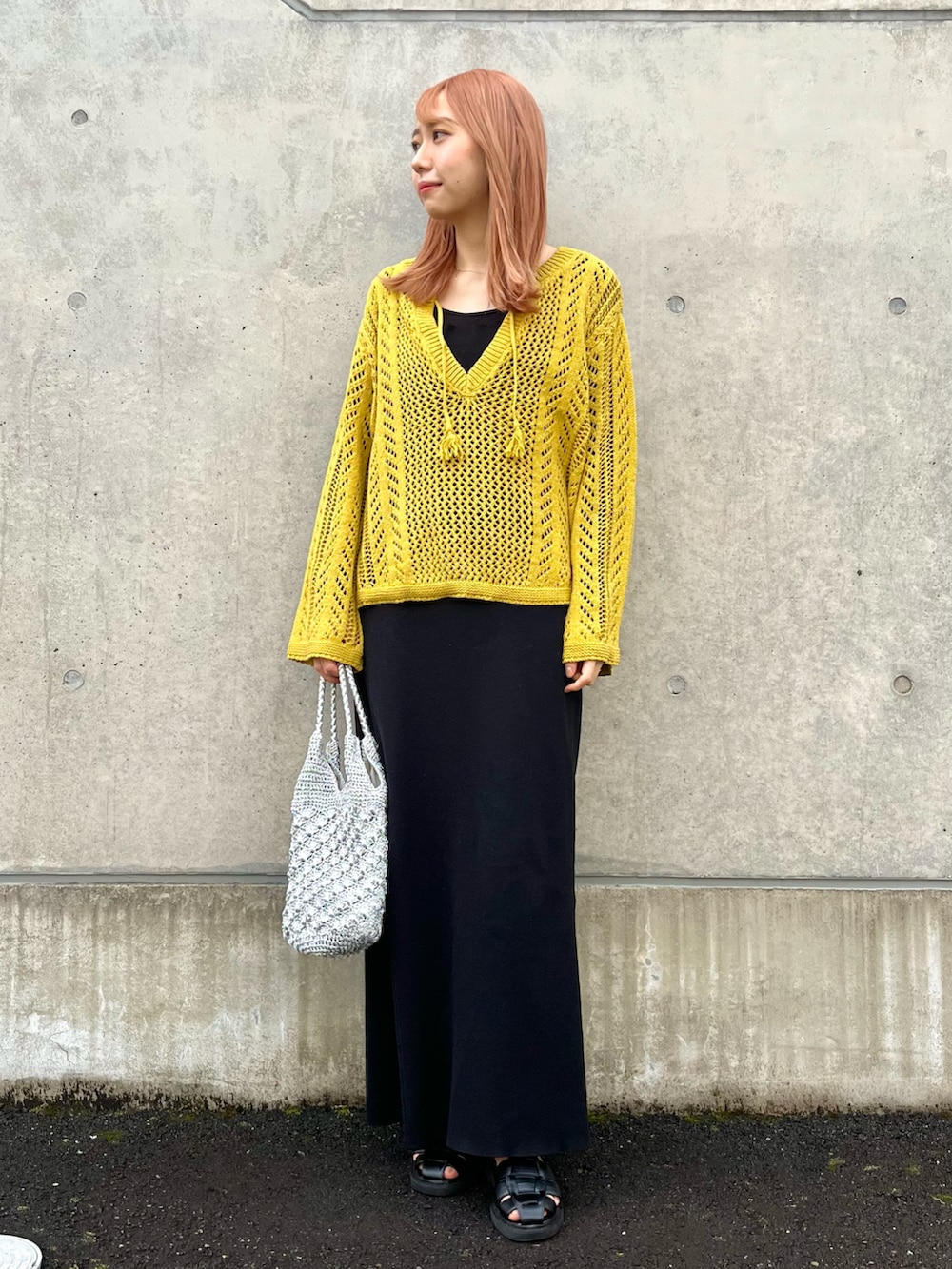 イエロー系のニット/セーター、ブラック系のサンダル、ブラック系のキャミソールを着用したレディースの春コーディネートの3枚目の写真