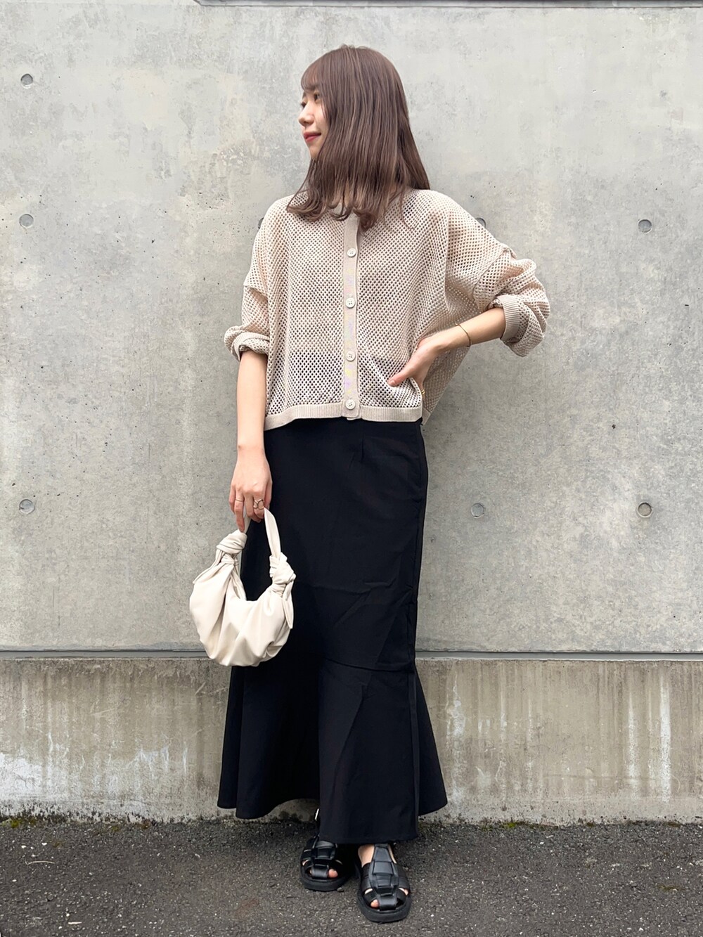 ベージュ系のカーディガン/ボレロ、ブラック系のスカート、ブラック系のサンダルを着用したレディースの春コーディネートの5枚目の写真
