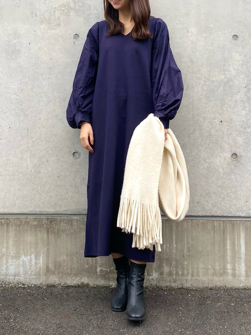 ブルー系のワンピース、ブラック系のブーツ、ホワイト系のマフラーを着用したレディースの秋コーディネートの3枚目の写真