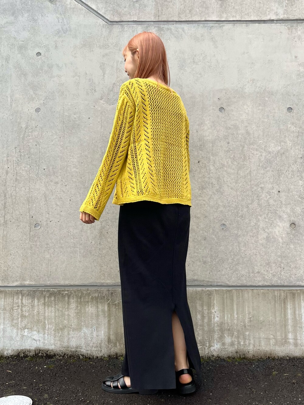 イエロー系のニット/セーター、ブラック系のサンダル、ブラック系のキャミソールを着用したレディースの春コーディネートの2枚目の写真