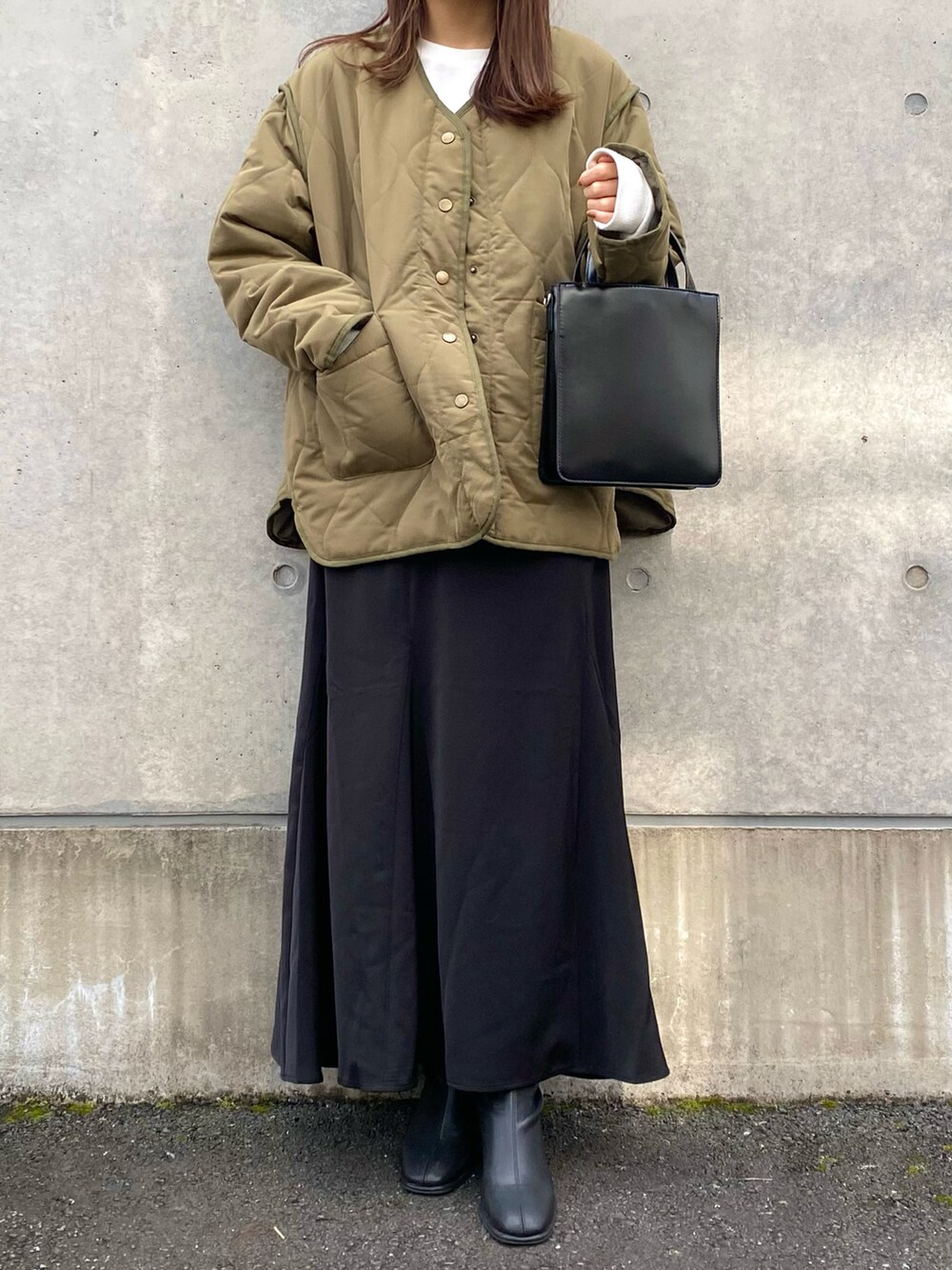 グリーン系のナイロンジャケット、ブラック系のスカート、ブラック系のショルダーバッグを着用したレディースの秋コーディネートの2枚目の写真