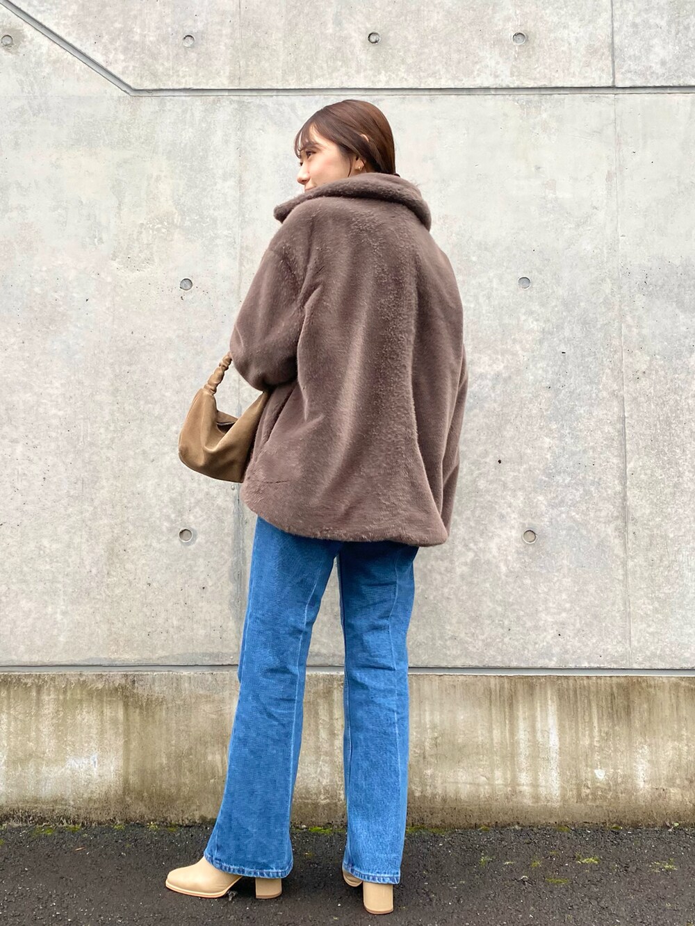 ホワイト系のニット/セーター、ブルー系のデニムパンツ、ベージュ系のブーツを着用したレディースの冬コーディネートの3枚目の写真