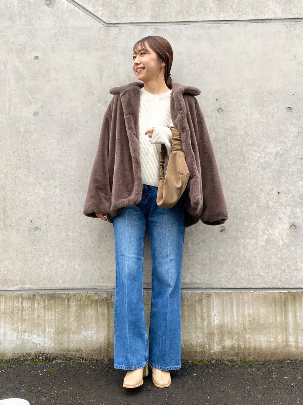 ホワイト系のニット/セーター、ブルー系のデニムパンツ、ベージュ系のブーツを着用したレディースの冬コーディネートの4枚目の写真