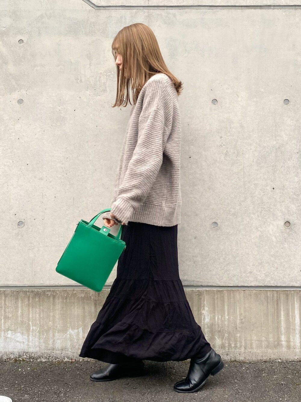 ブラック系のスカート、ホワイト系のTシャツ/カットソー、グレー系のニット/セーターを着用したレディースの冬コーディネートの3枚目の写真