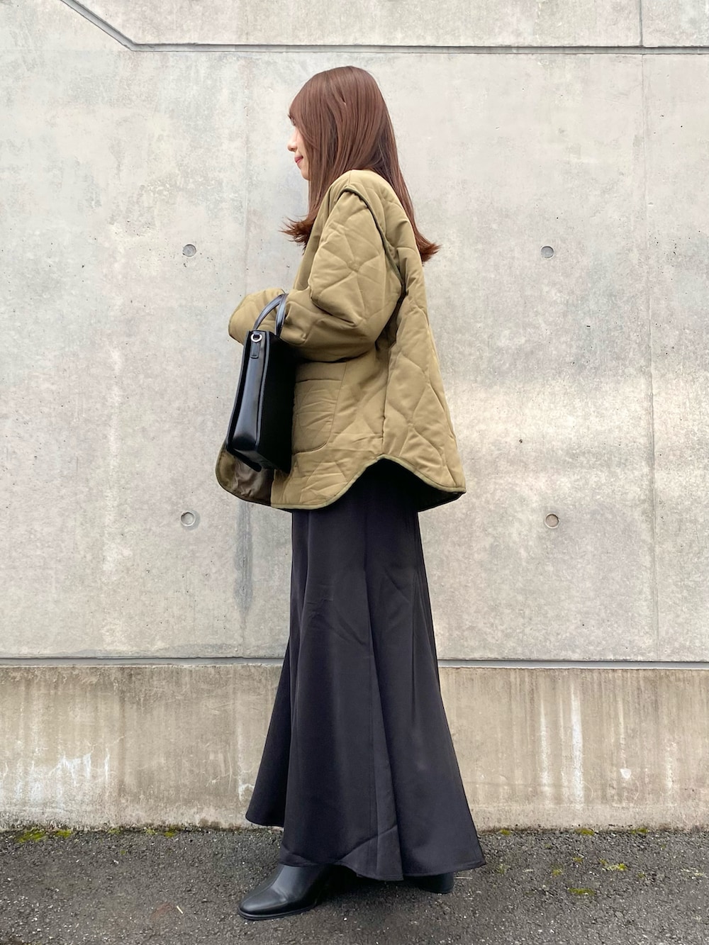 グリーン系のナイロンジャケット、ブラック系のスカート、ブラック系のショルダーバッグを着用したレディースの秋コーディネートの3枚目の写真