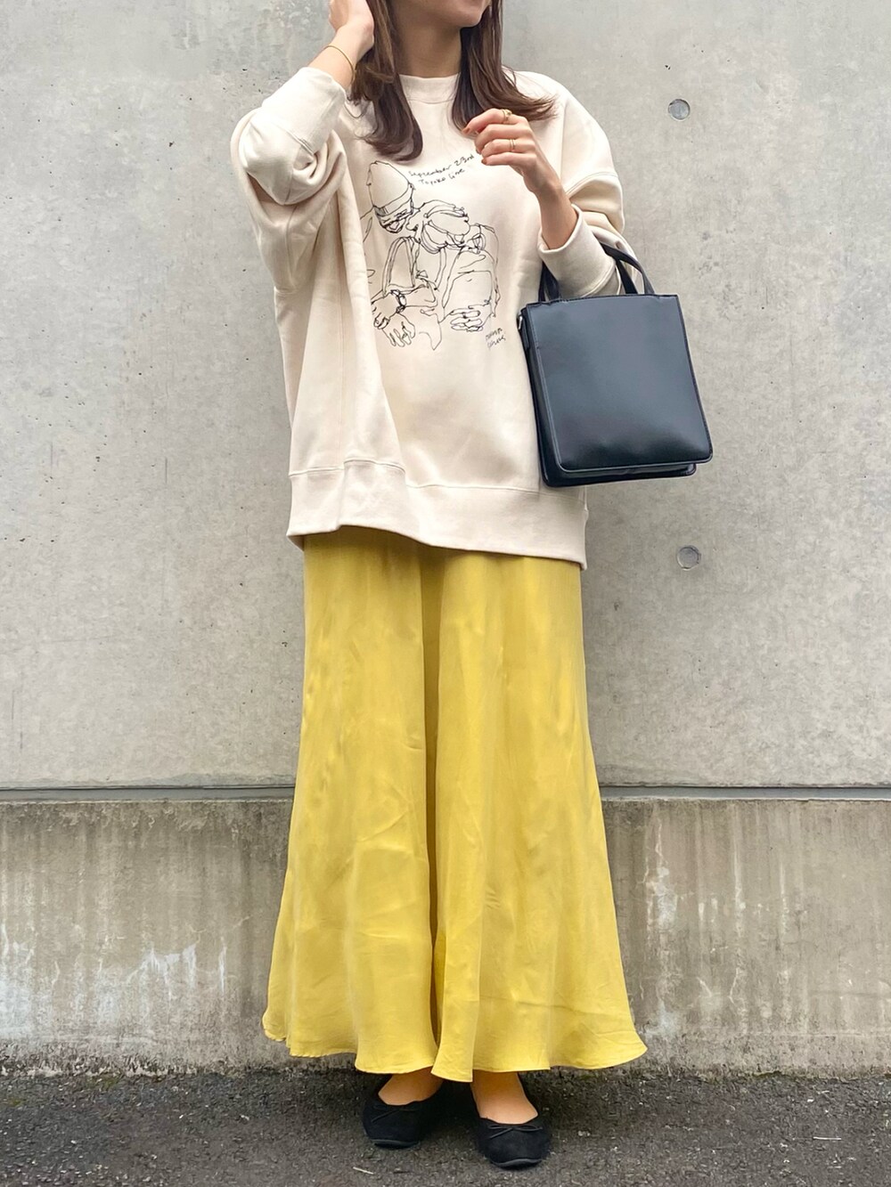 ホワイト系のスウェット、イエロー系のスカート、ブラック系のバレエシューズを着用したレディースの秋コーディネートの2枚目の写真