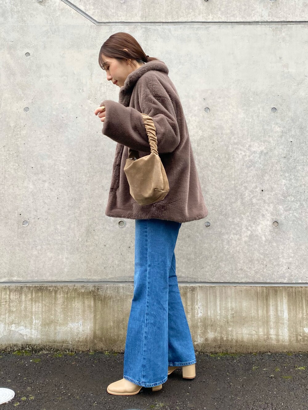 ホワイト系のニット/セーター、ブルー系のデニムパンツ、ベージュ系のブーツを着用したレディースの冬コーディネートの2枚目の写真