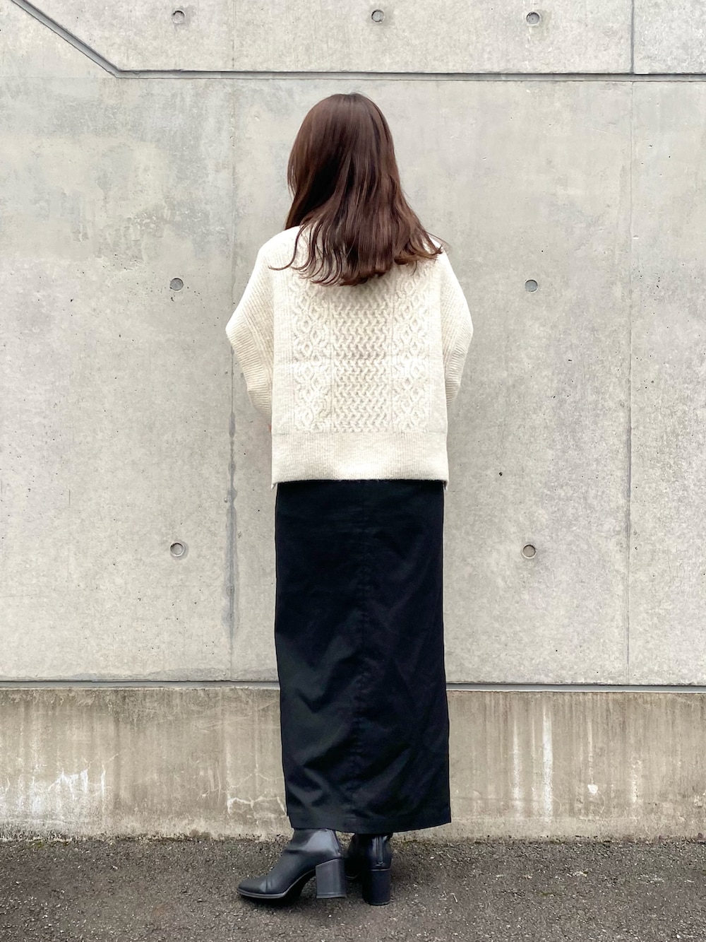 ホワイト系のベスト、ブラック系のスカート、ブラック系のブーツを着用したレディースの秋コーディネートの3枚目の写真