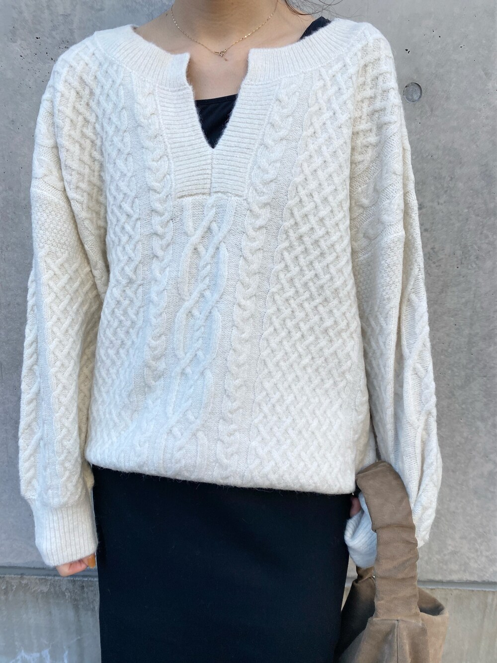 ホワイト系のニット/セーター、ブラック系のスカート、ブラック系のキャミソールを着用したレディースの冬コーディネートの3枚目の写真