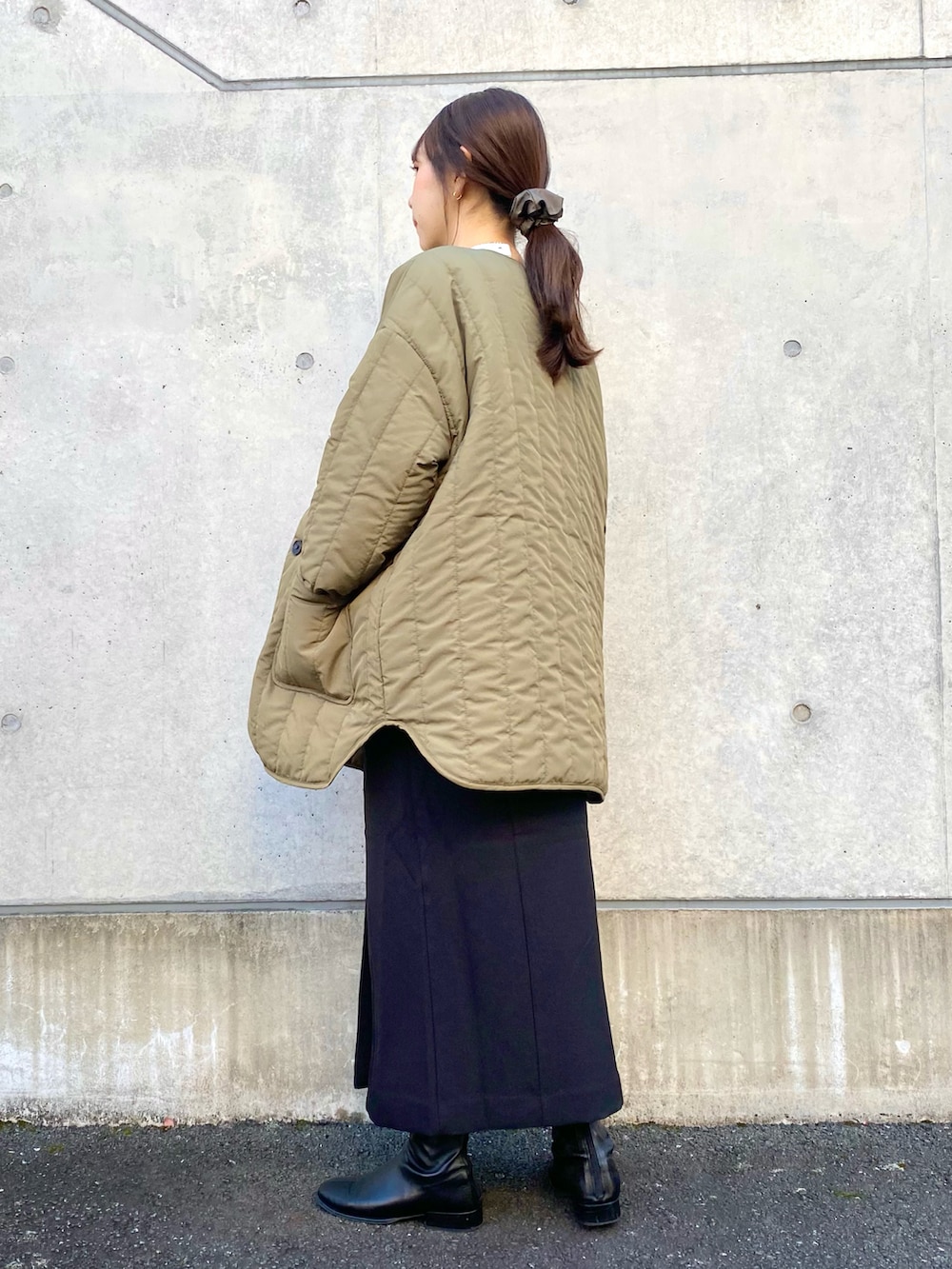 グリーン系のその他アウター、ブラック系のジャンパースカート、ホワイト系のTシャツ/カットソーを着用したレディースの冬コーディネートの3枚目の写真