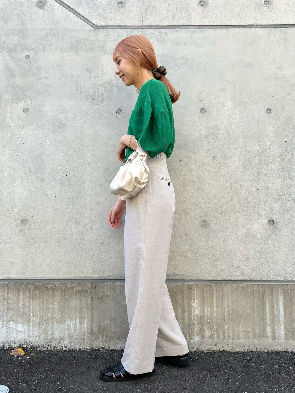 グリーン系のニット/セーター、ベージュ系のその他パンツ、ブラック系のサンダルを着用したレディースの春コーディネートの3枚目の写真