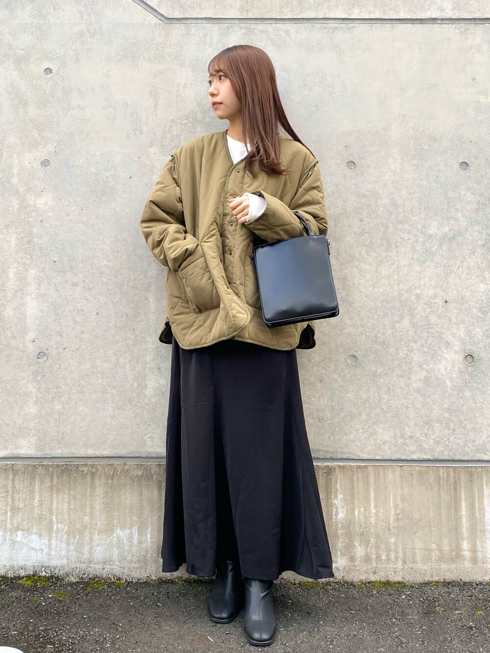 グリーン系のナイロンジャケット、ブラック系のスカート、ブラック系のショルダーバッグを着用したレディースの秋コーディネートの4枚目の写真
