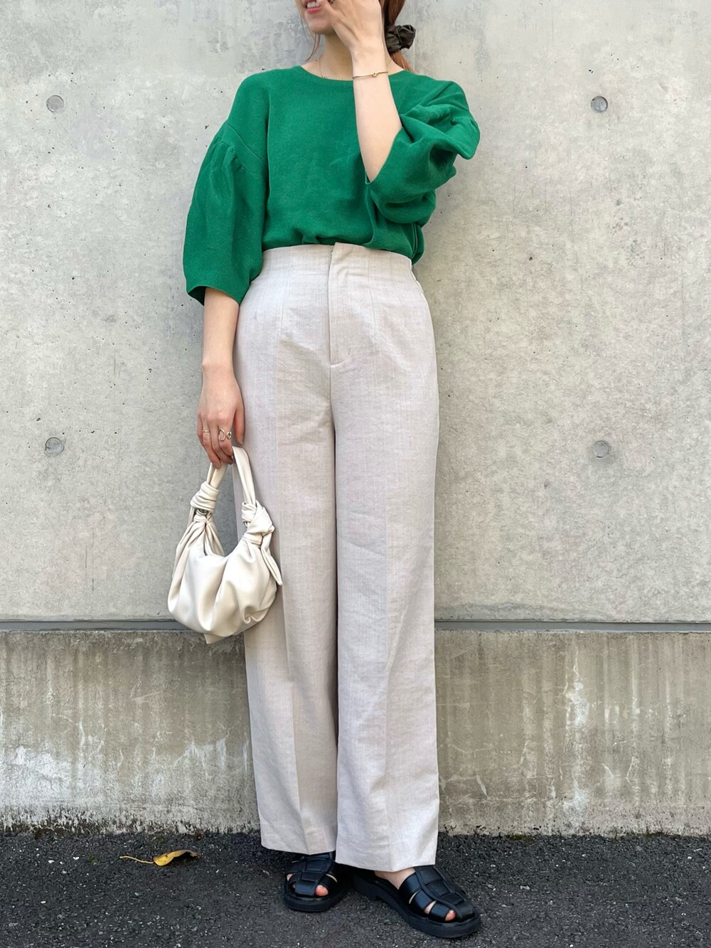 グリーン系のニット/セーター、ベージュ系のその他パンツ、ブラック系のサンダルを着用したレディースの春コーディネートの2枚目の写真