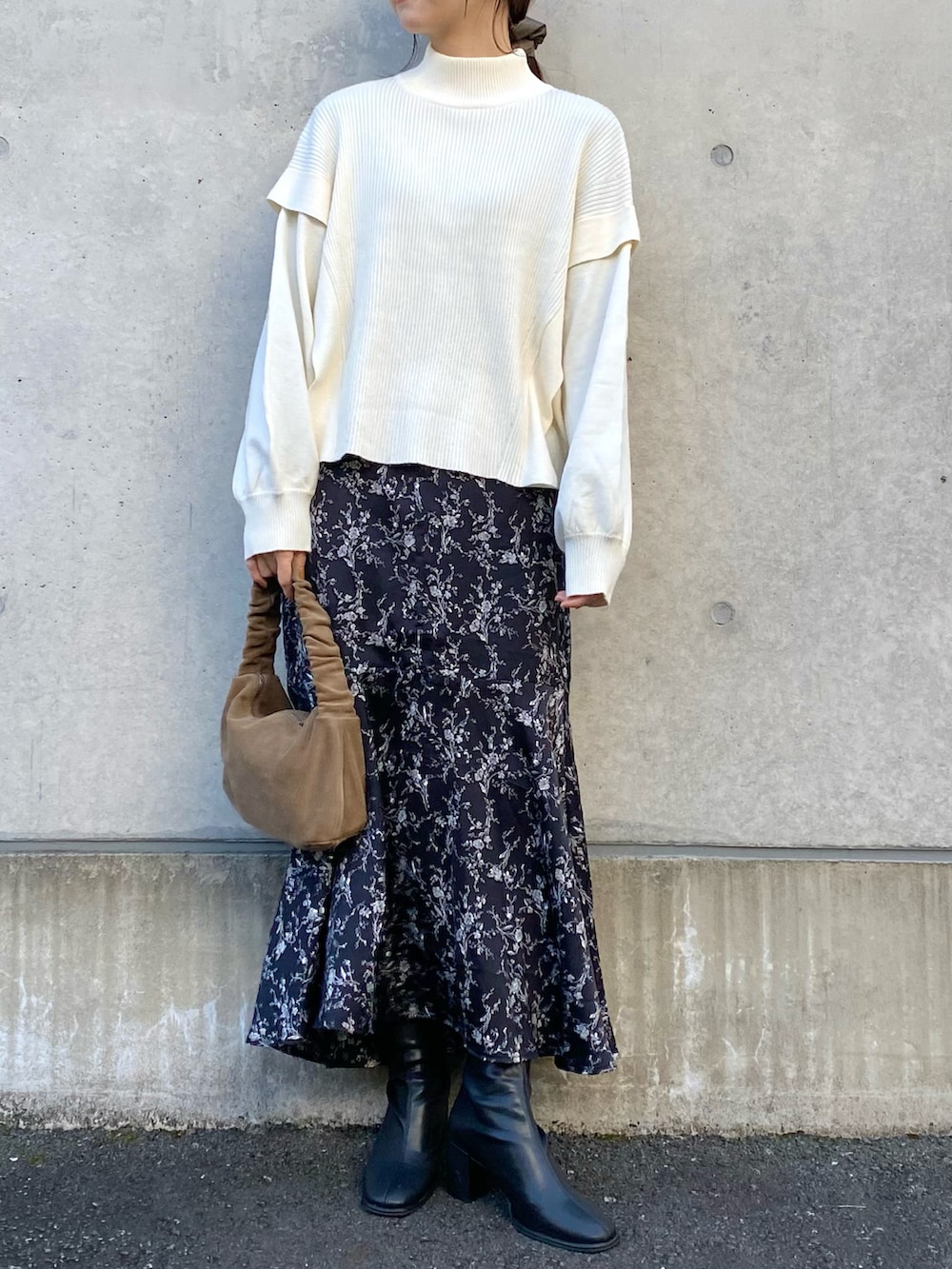 ホワイト系のニット/セーター、ブラック系のスカート、ブラック系のブーツを着用したレディースの冬コーディネートの2枚目の写真