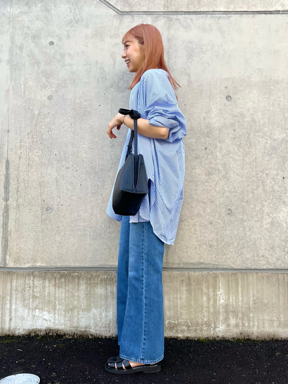 ブルー系のシャツ/ブラウス、ブルー系のデニムパンツ、ブラック系のサンダルを着用したレディースの春コーディネートの3枚目の写真