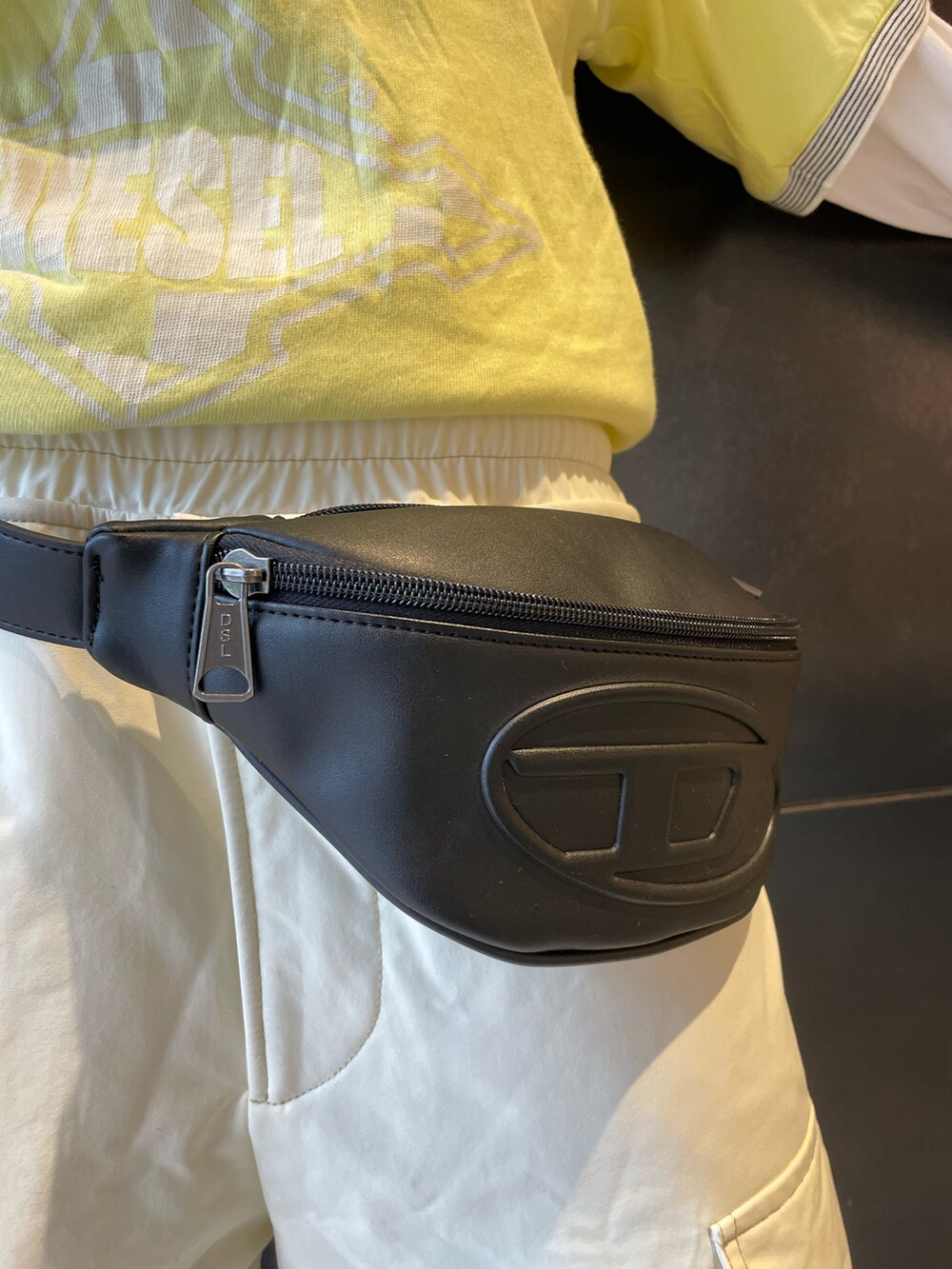 ブラック系のスニーカー、イエロー系のTシャツ/カットソー、ブラック系のボディバッグ/ウエストポーチを着用したレディースの春コーディネートの2枚目の写真