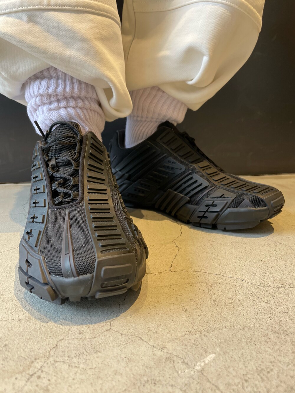 ブラック系のスニーカー、イエロー系のTシャツ/カットソー、ブラック系のボディバッグ/ウエストポーチを着用したレディースの春コーディネートの3枚目の写真