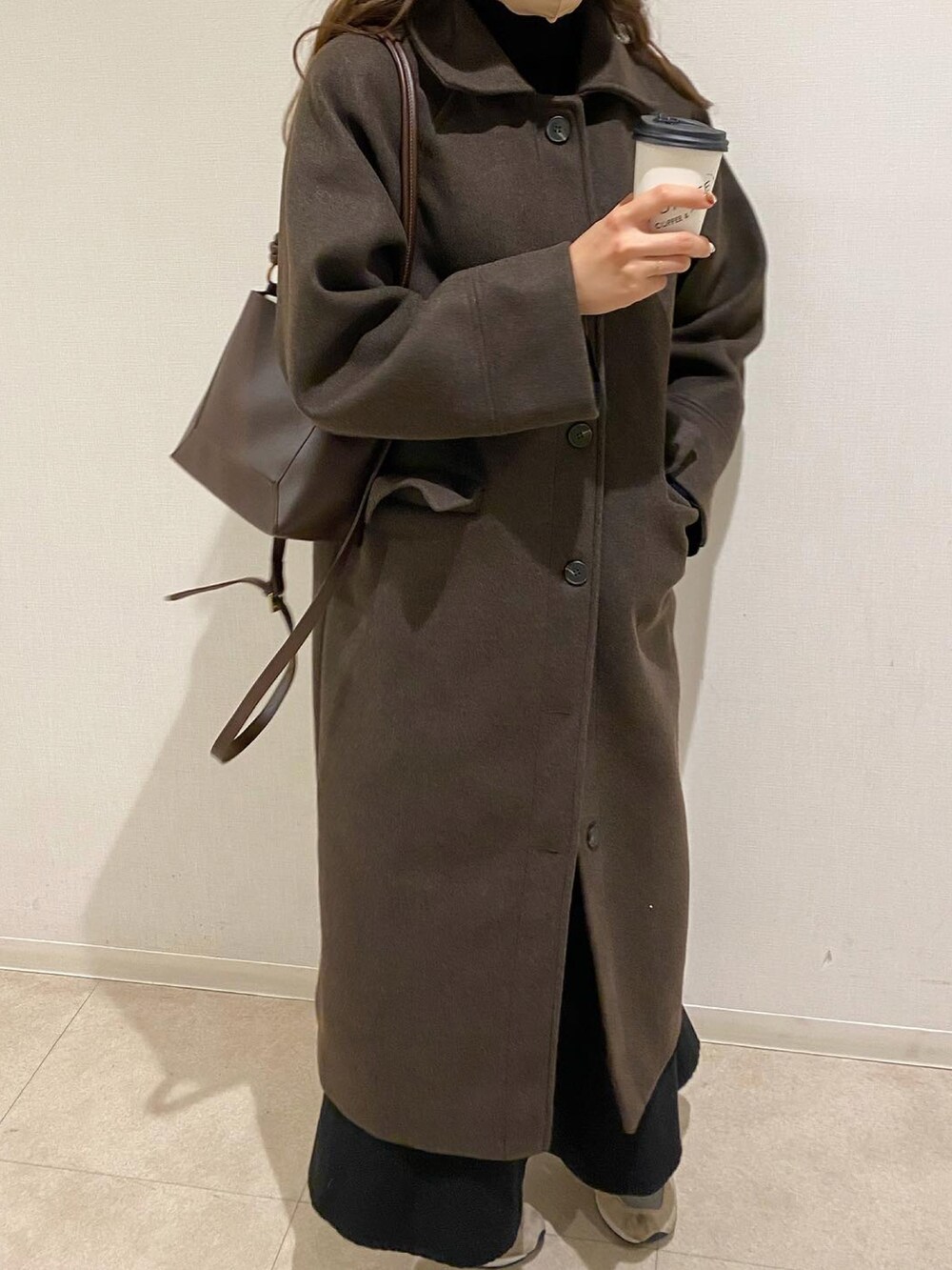 ブラウン系のニット/セーター、ブラウン系のスカート、ブラウン系のキャップを着用したレディースの冬コーディネートの3枚目の写真