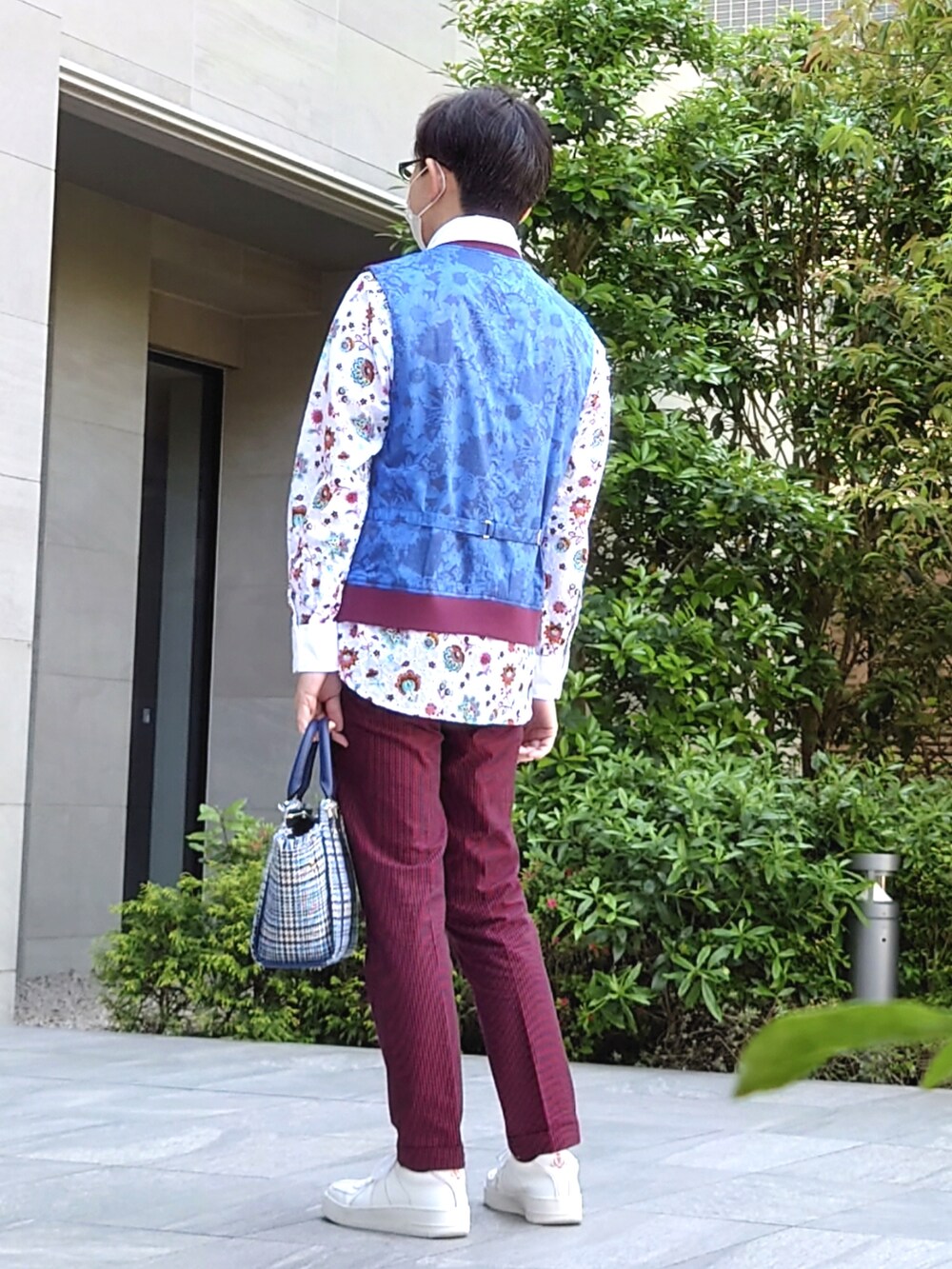 ブルー系のハンドバッグ、レッド系のパンツ、ホワイト系のスニーカーを着用したメンズの春コーディネートの2枚目の写真