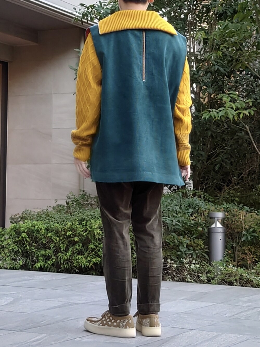 グリーン系のパンツ、ベージュ系のモカシン/デッキシューズ、グリーン系のベストを着用したメンズの秋コーディネートの2枚目の写真