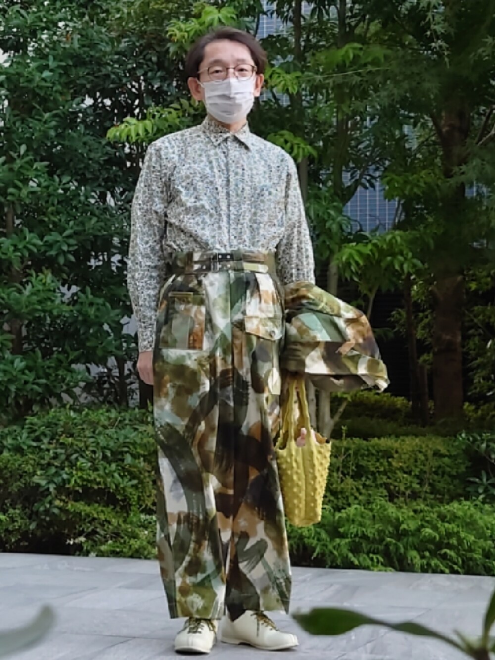 イエロー系のハンドバッグ、ホワイト系のドレスシューズ、グリーン系のジャケット/アウターを着用したメンズの秋コーディネートの2枚目の写真