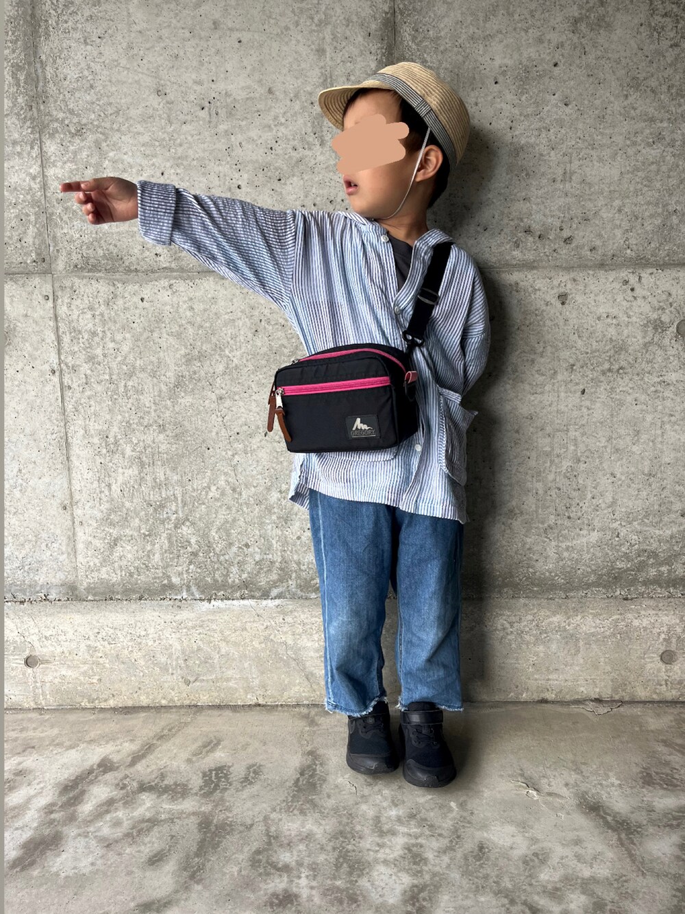 ピンク系のショルダーバッグ、ブルー系のデニムパンツ、ブラック系のスニーカーを着用したキッズの春コーディネートの2枚目の写真