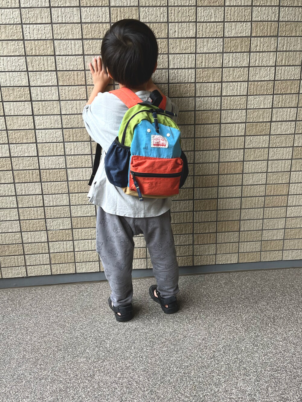 グリーン系のTシャツ/カットソー、グレー系のパンツ、ブラック系のサンダルを着用したキッズの秋コーディネートの2枚目の写真