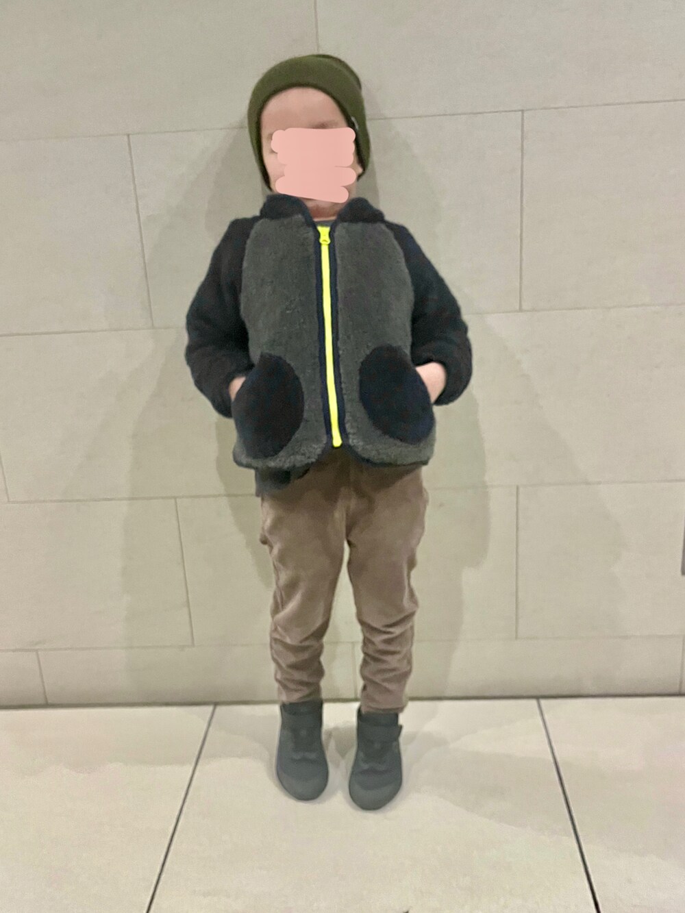 ブルー系のジャケット/アウター、ブラック系のスニーカー、グリーン系のニットキャップ/ビーニーを着用したキッズの冬コーディネートの2枚目の写真