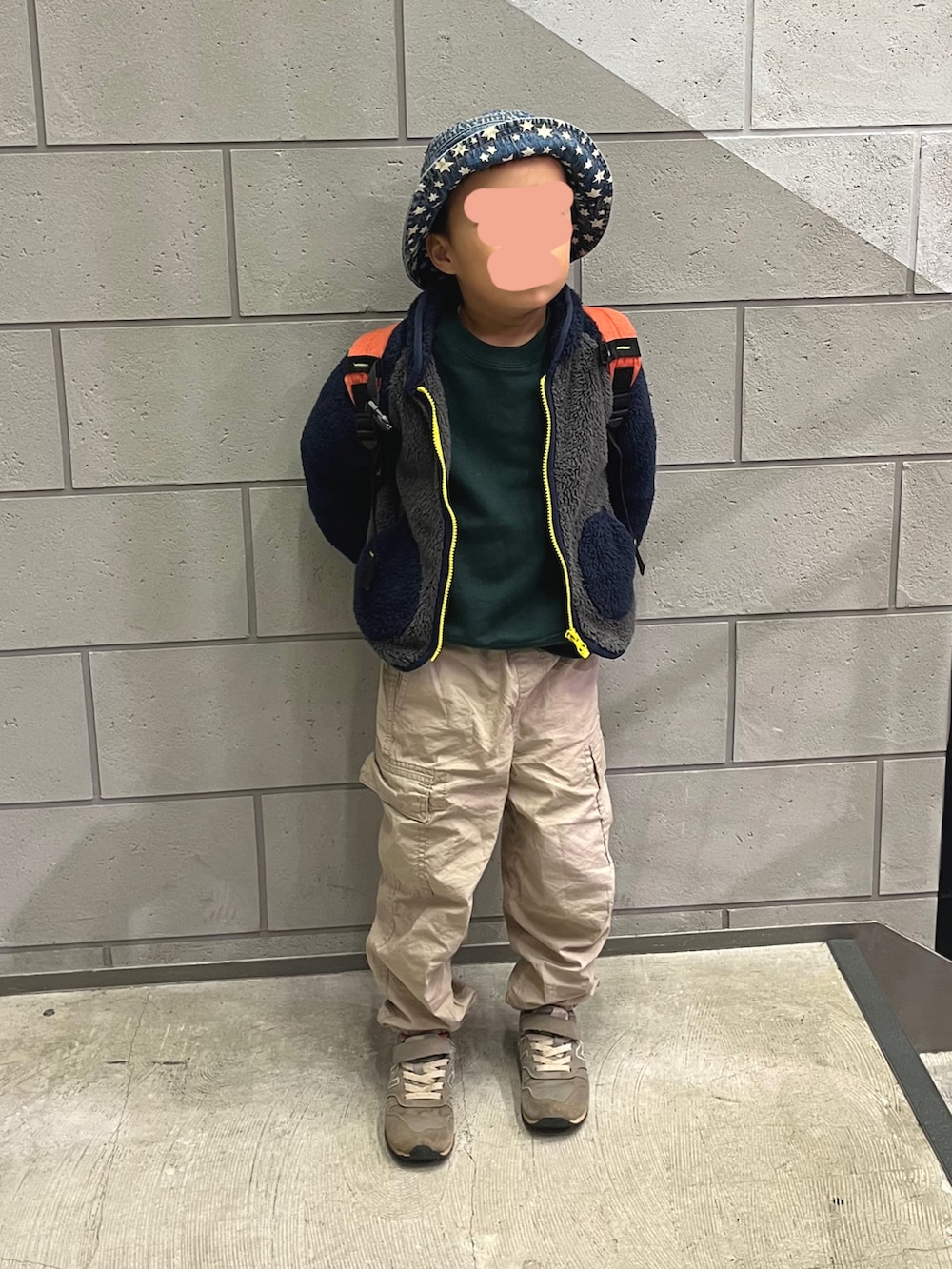 ブルー系のジャケット/アウター、ブルー系のバックパック/リュック、ベージュ系のカーゴパンツを着用したキッズの冬コーディネートの2枚目の写真