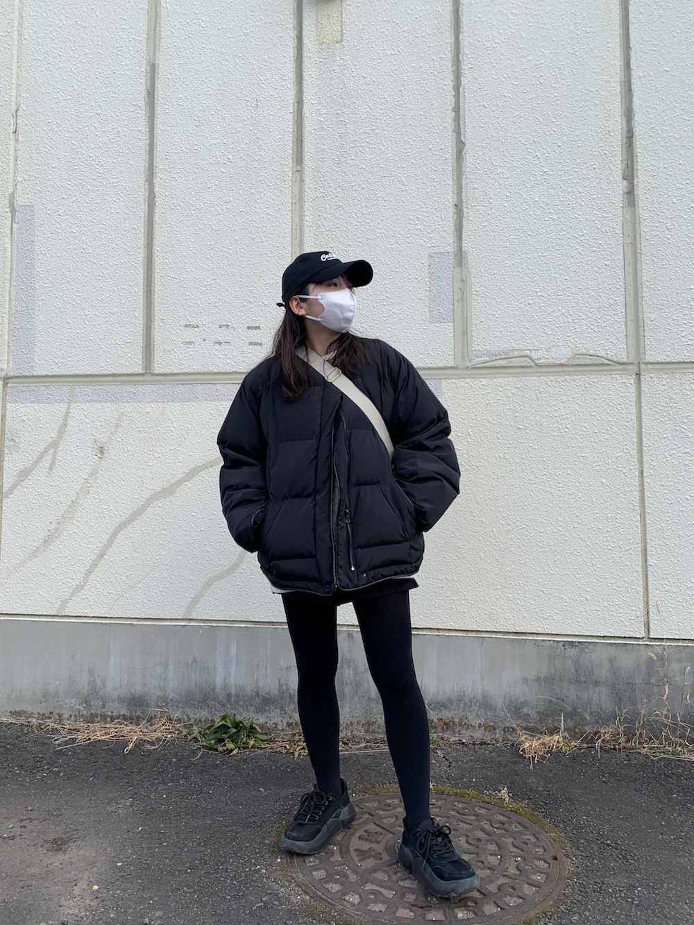 ブラック系のブルゾン、ブラック系のスニーカー、ブラック系のパンツを着用したレディースの冬コーディネートの2枚目の写真