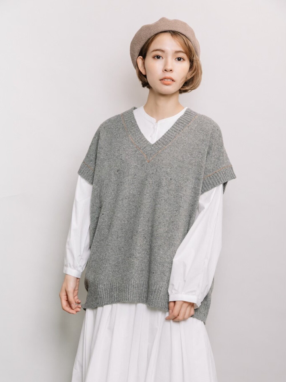 グレー系のベスト、ホワイト系のシャツ/ブラウス、ホワイト系のスカートを着用したレディースの冬コーディネートの5枚目の写真