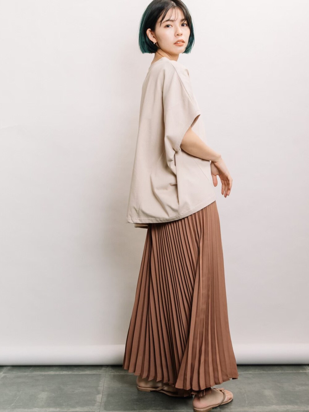 ベージュ系のTシャツ/カットソー、ブラウン系のスカートを着用したレディースの春コーディネートの2枚目の写真