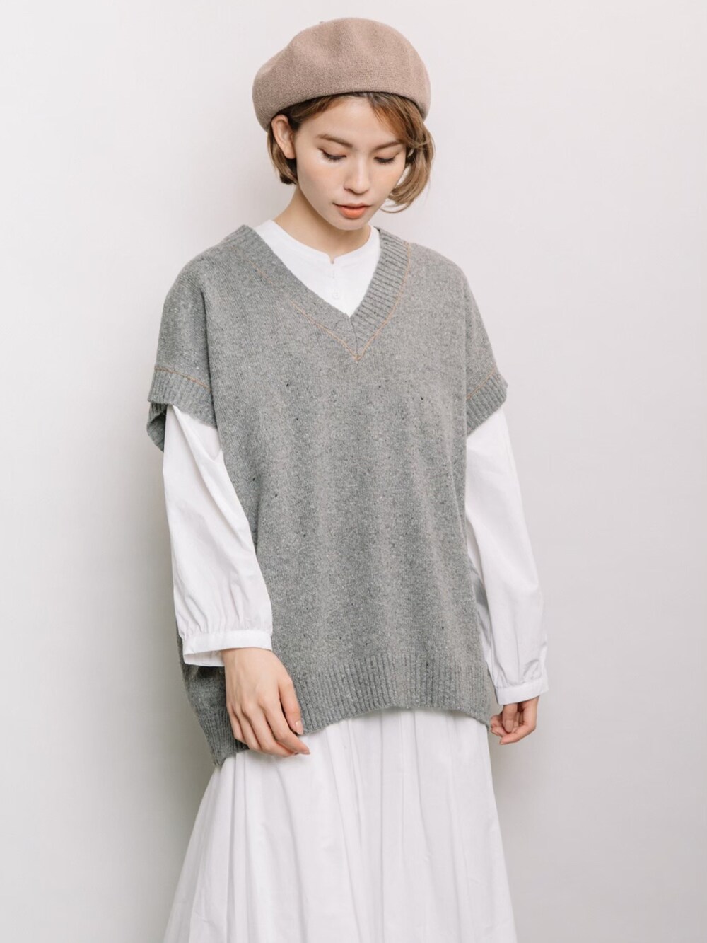 グレー系のベスト、ホワイト系のシャツ/ブラウス、ホワイト系のスカートを着用したレディースの冬コーディネートの4枚目の写真