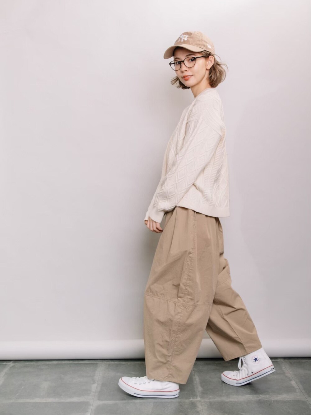 ホワイト系のニット/セーター、ベージュ系のその他パンツ、ホワイト系のスニーカーを着用したレディースの春コーディネートの3枚目の写真