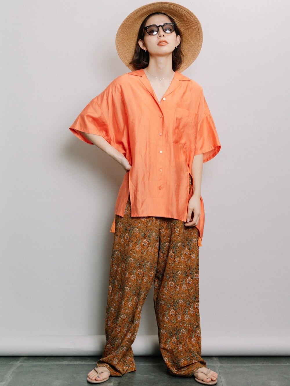 オレンジ系のシャツ/ブラウス、オレンジ系のその他パンツ、ベージュ系のハットを着用したレディースの夏コーディネートの2枚目の写真