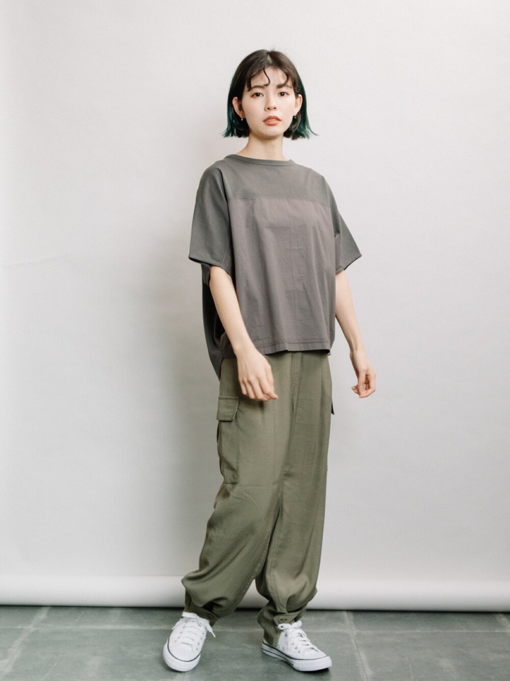 グレー系のTシャツ/カットソー、グリーン系のその他パンツ、ホワイト系のスニーカーを着用したレディースの春コーディネートの2枚目の写真