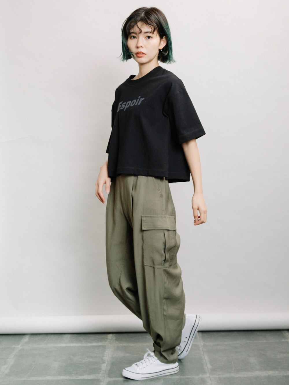 ブラック系のTシャツ/カットソー、グリーン系のその他パンツ、ホワイト系のスニーカーを着用したレディースの春コーディネートの3枚目の写真
