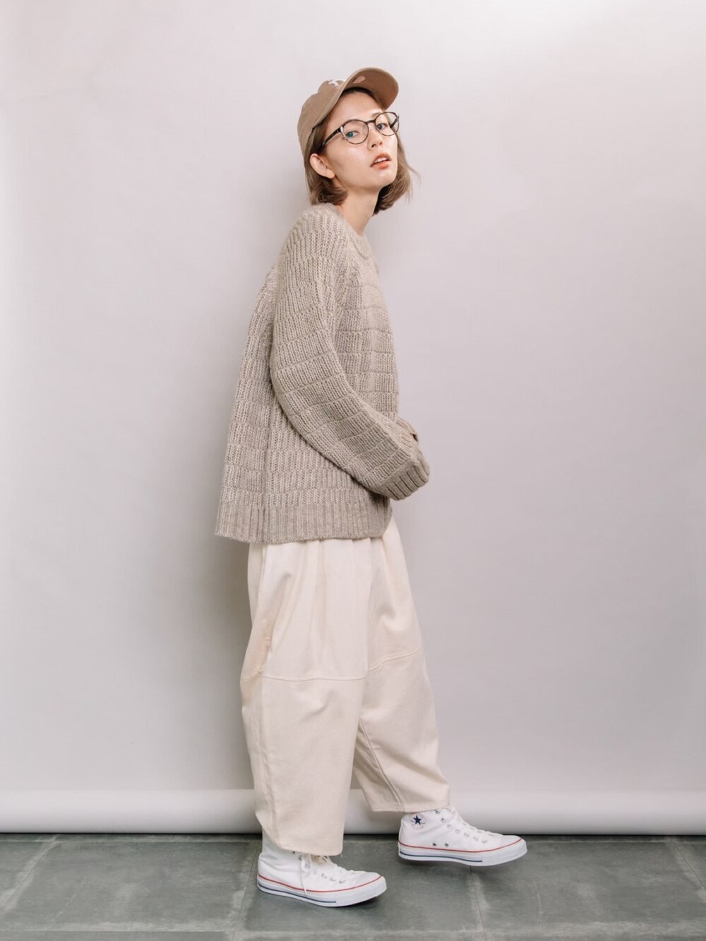 ベージュ系のニット/セーター、ホワイト系のその他パンツ、ホワイト系のスニーカーを着用したレディースの秋コーディネートの3枚目の写真